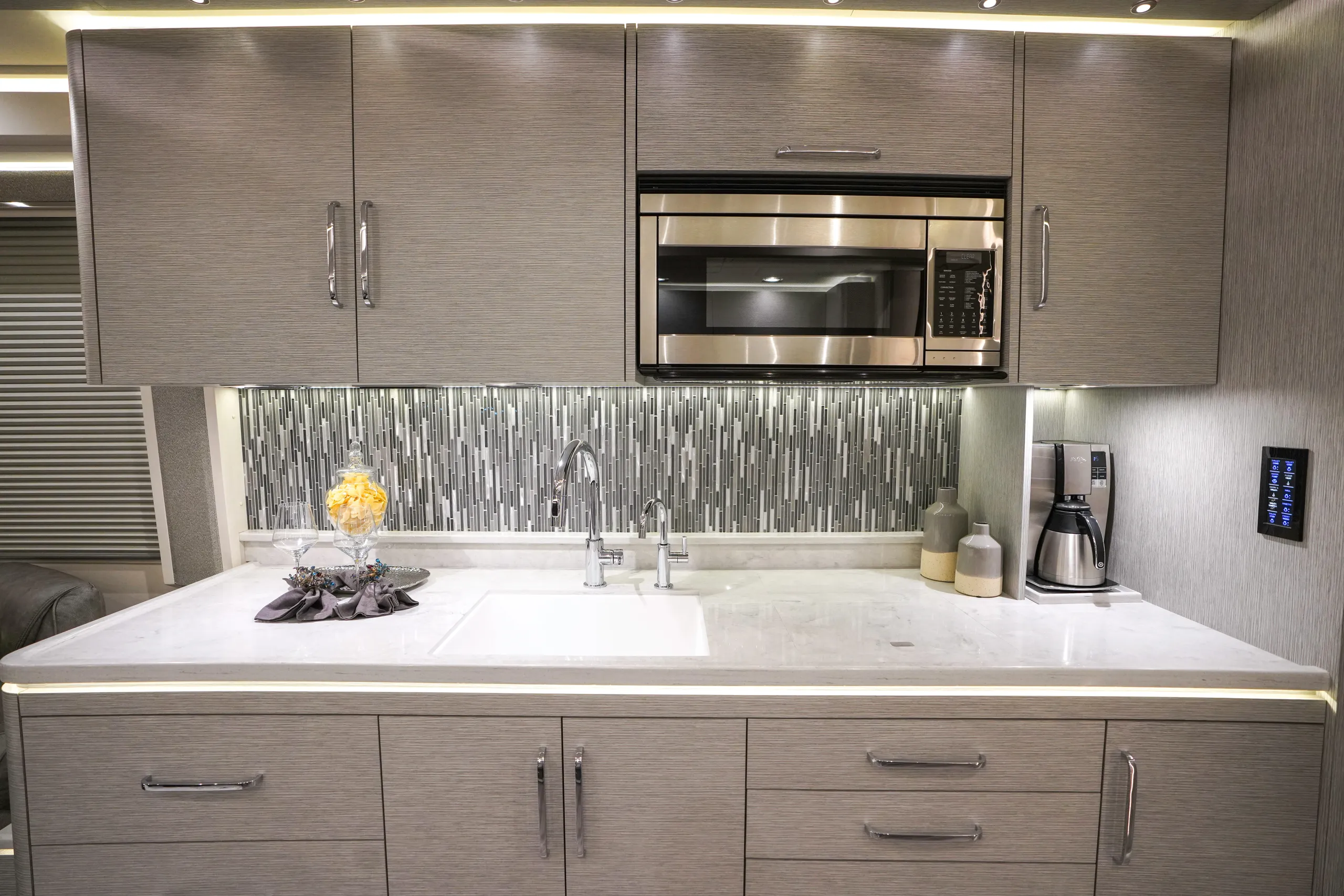 An RV kitchen with dazzling underlighting and marble accents