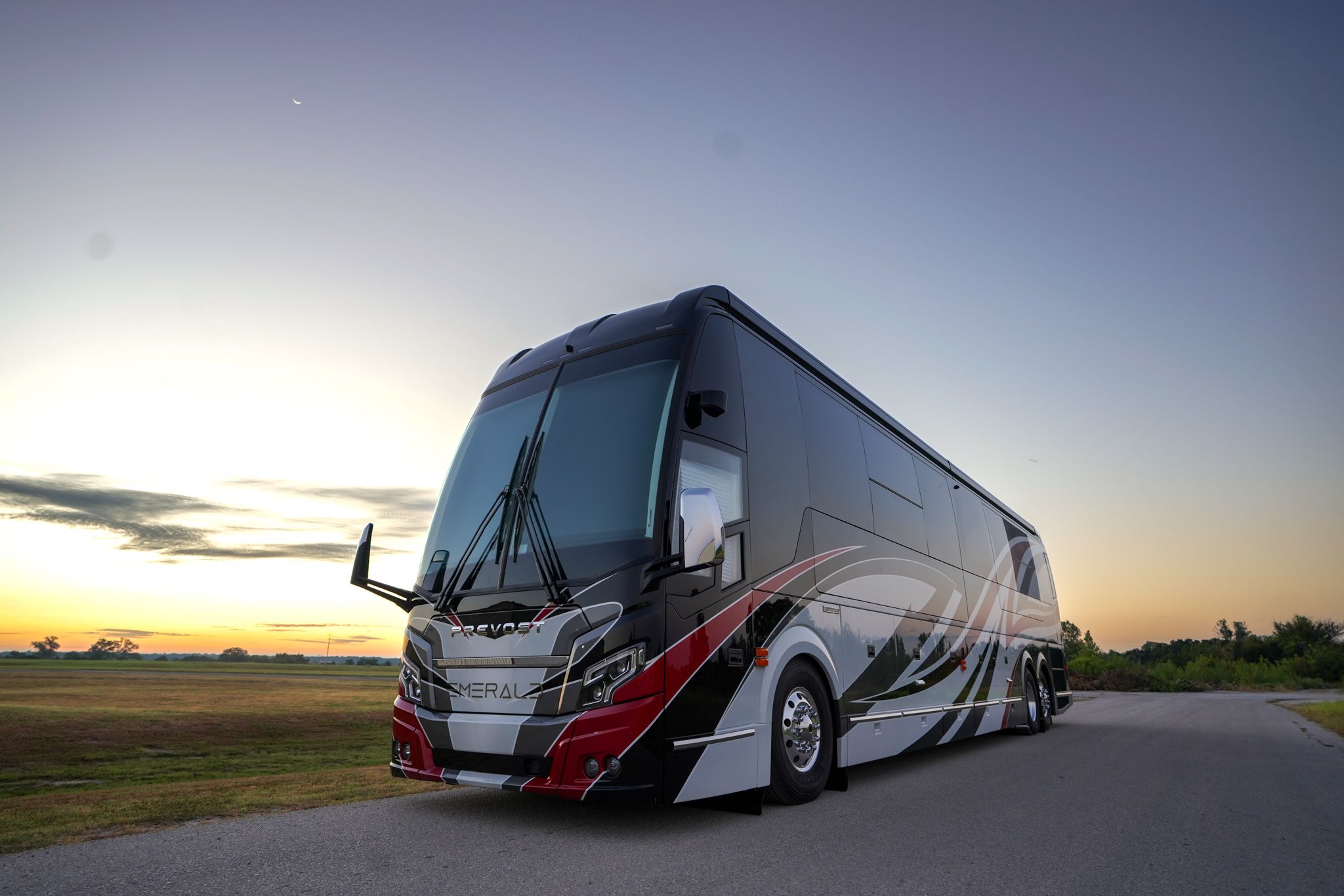 A red and white motorcoach parked laterally relative to the camera