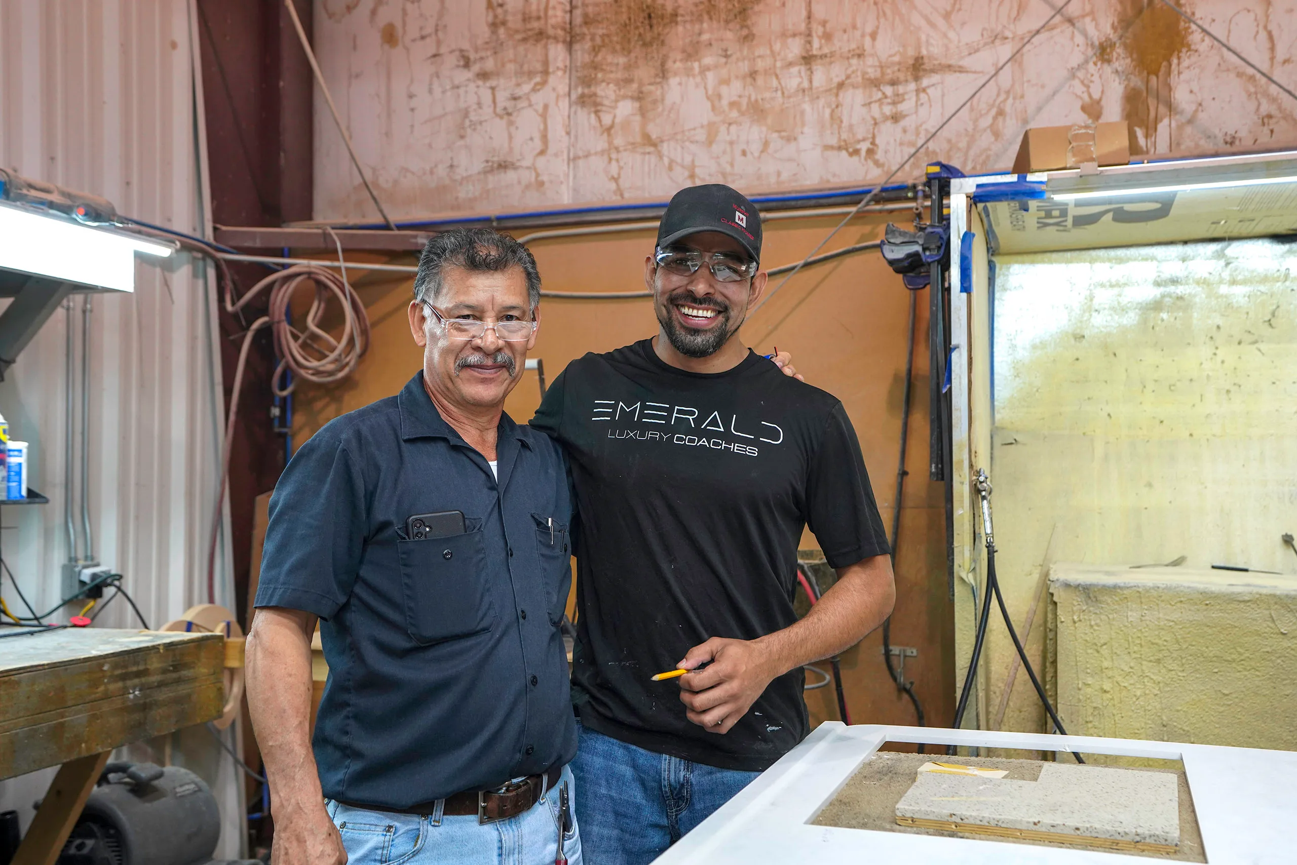 Two smiling men, hard at work inside of the Emerald warehouse